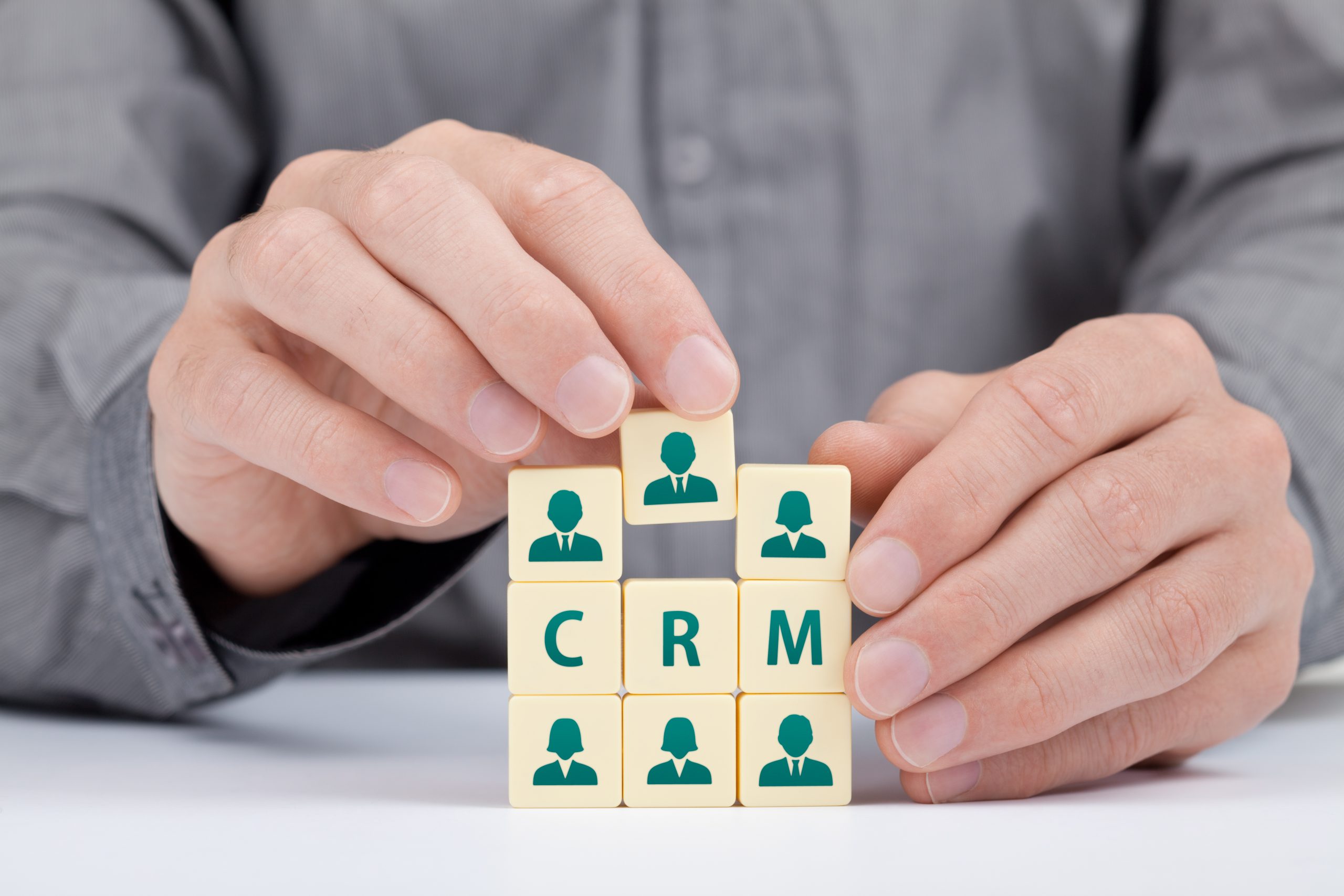 three building blocks labeled CRM in between six building blocks with a person icon